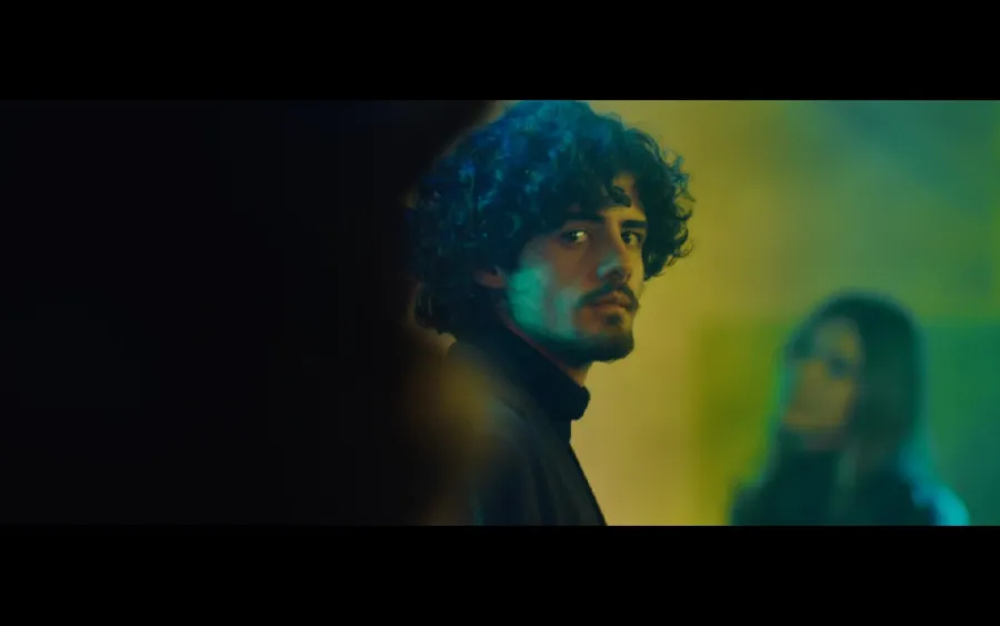 Frame from a film shot by Roman Kantsir — a young man in teal light